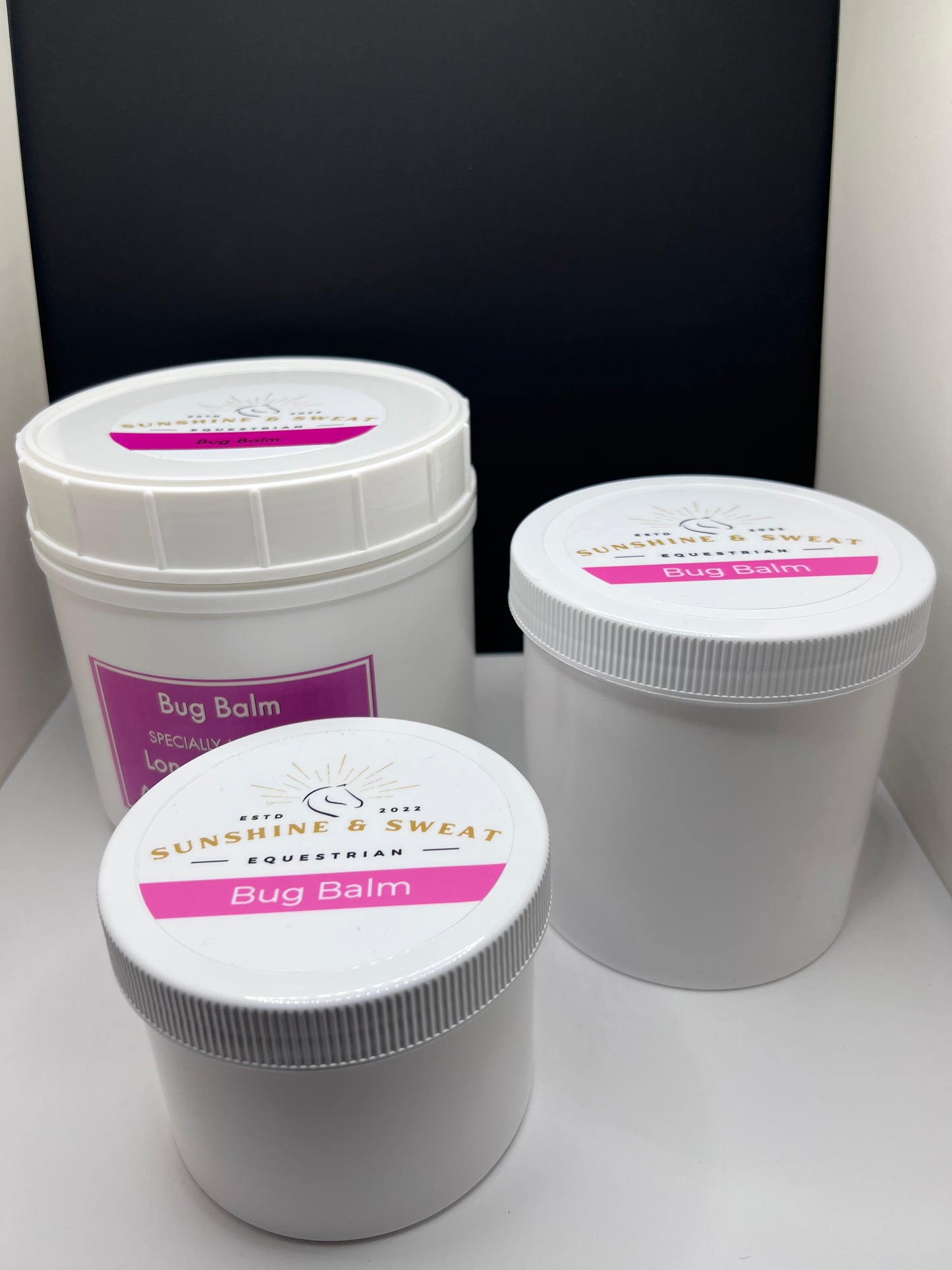 Three different sizes of healing. bug balm in white containers