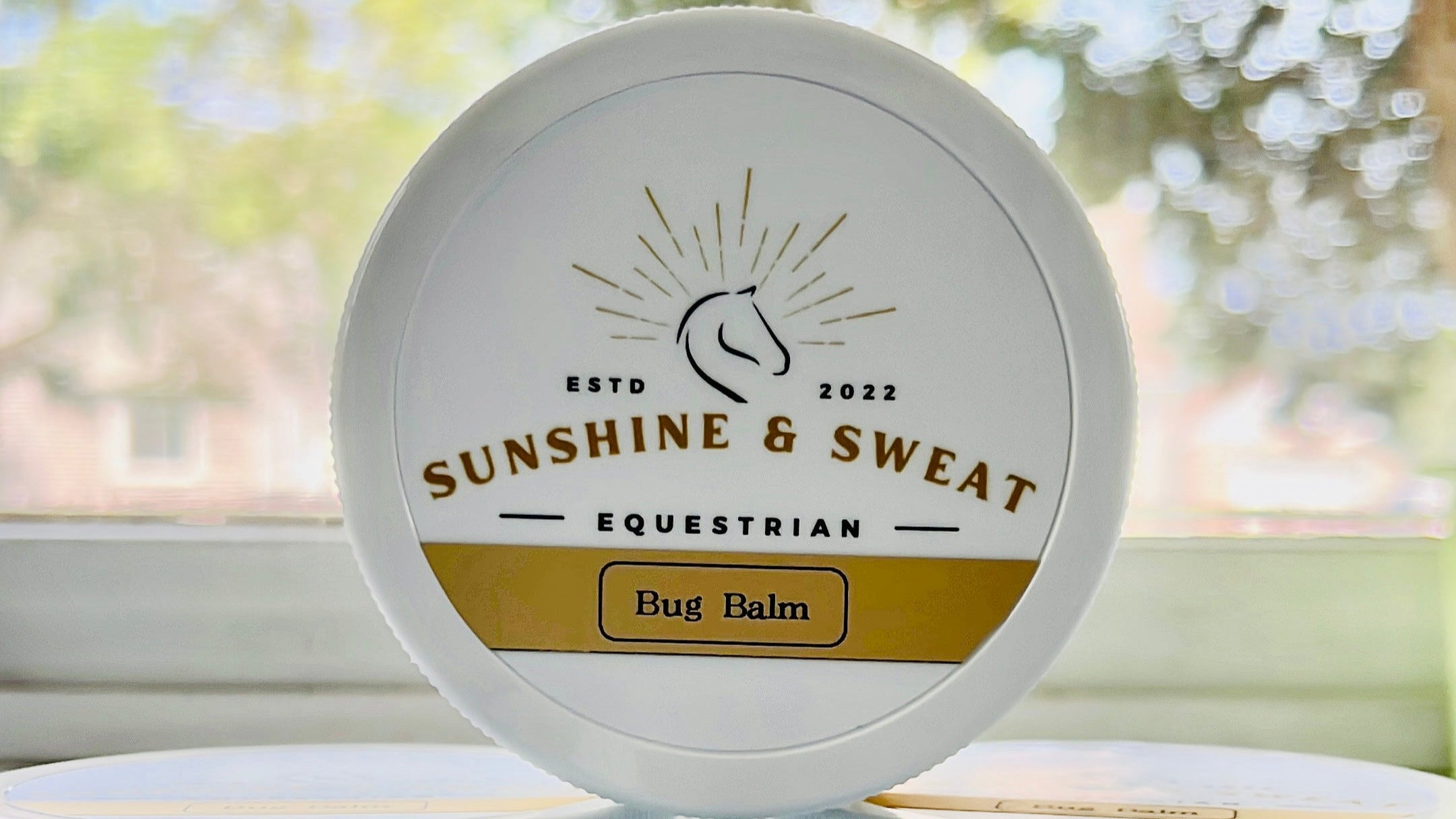 Bug_Balm White jar with white and gold label, one jar stacked on two jars